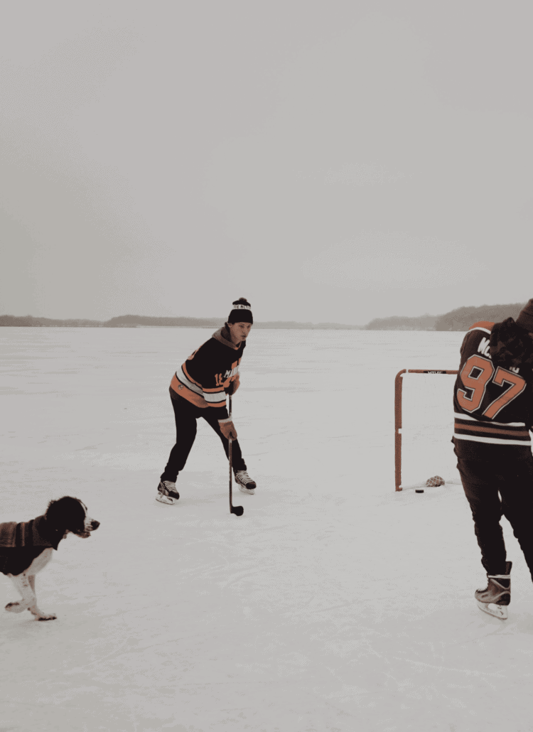 Under the text is a photo of a dog and his owners on an ice hockey rink.