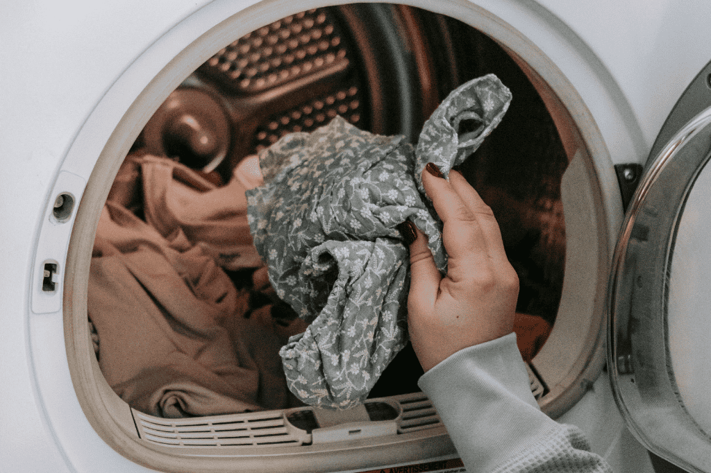 a woman showing the answer to can you wash a dog bed with stuffing in the washer.